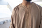 Caramel Linen thobe — neckline detail outdoors